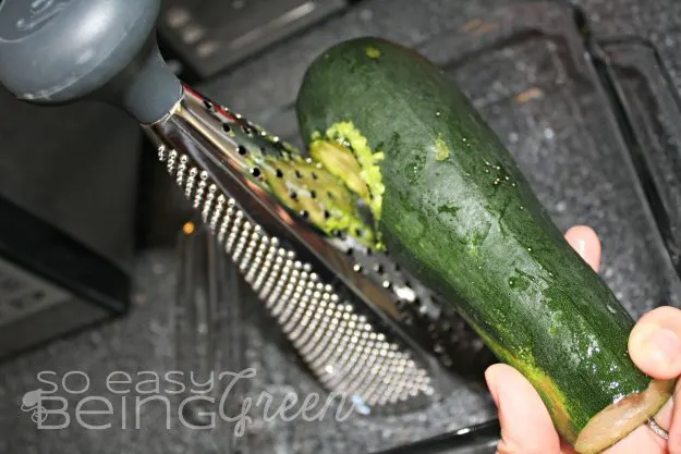 grating zucchini over glass bowl