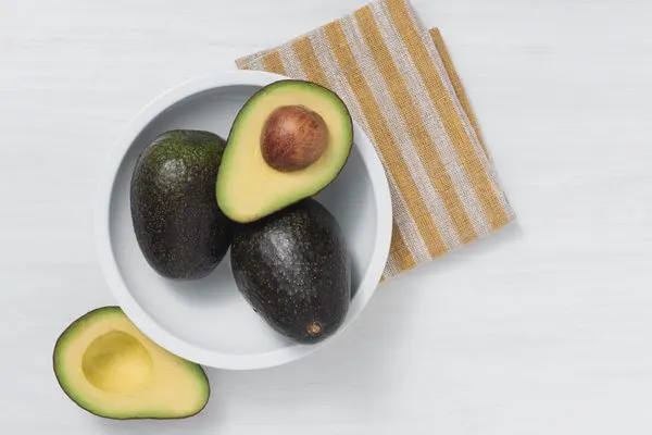 avocados in a bowl with dish towel