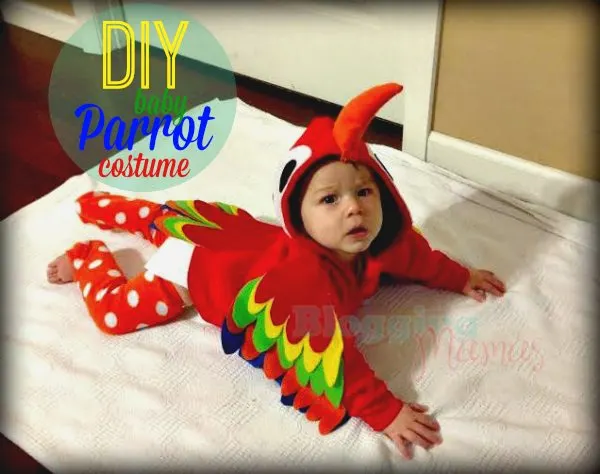 Baby dressed as a parrot laying on blanket