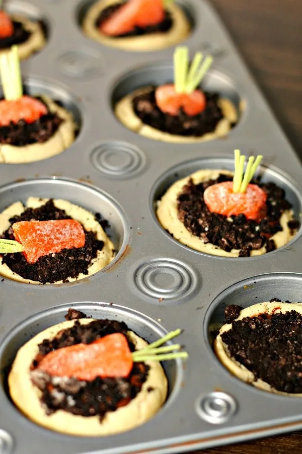 Carrot patch cookie cups; candy carrots inside dirt made of chocolate inside muffin pan