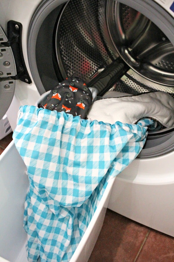 cloth diapers and cloth diaper pail liner in front loading washing machine