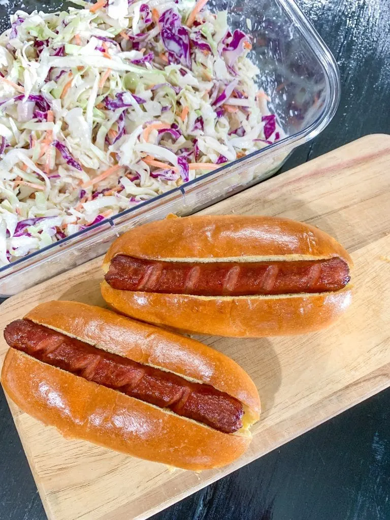 hot dogs on cutting board with coleslaw 