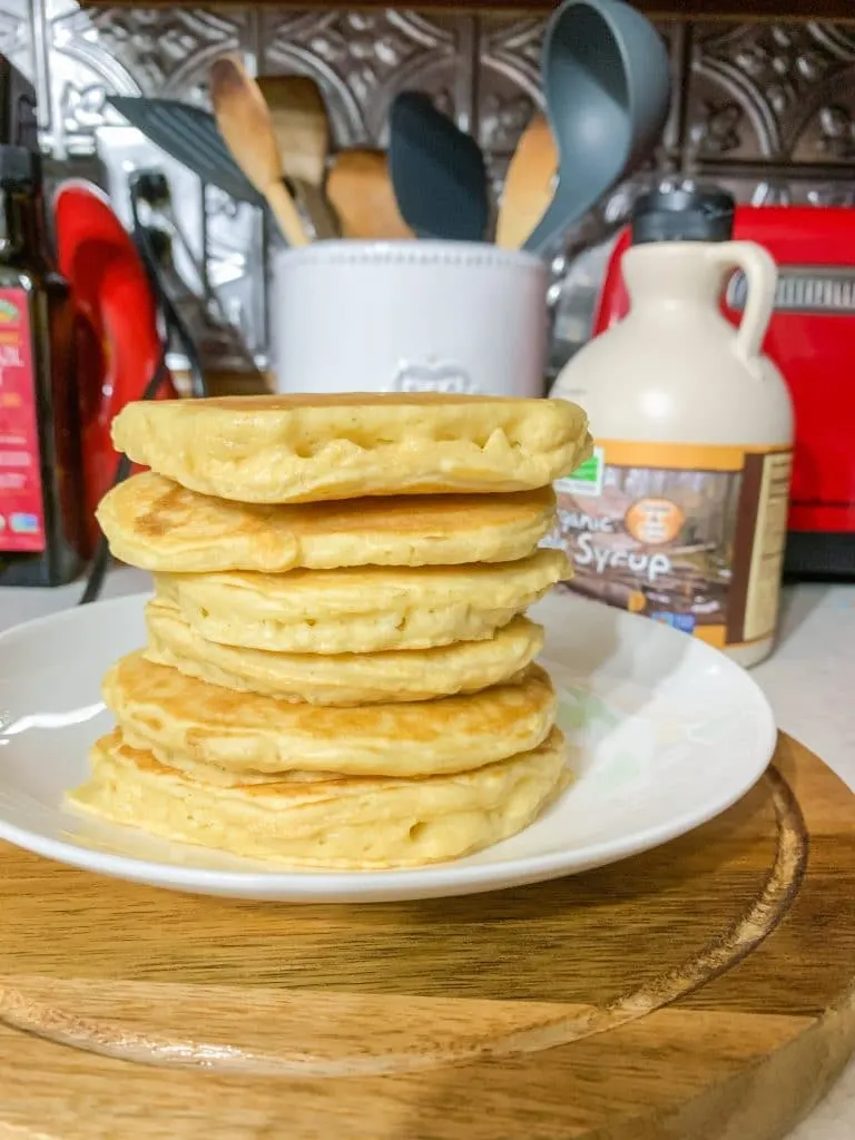 stack of almond milk pancakes on plate with maple syrup