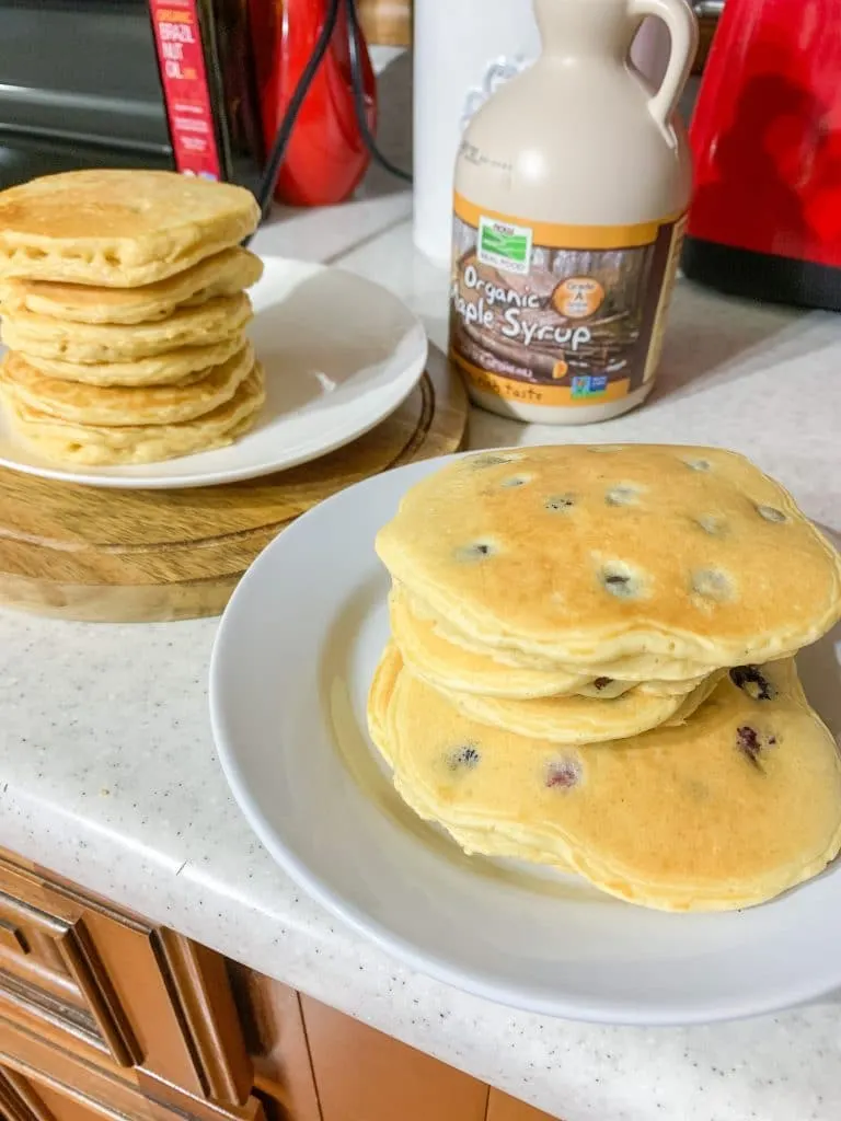 plates of almond milk pancakes with pancake add ins like blueberries